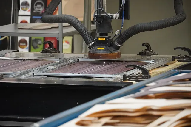 A CNC laser cutting machine working on wooden components at the C.F. Martin Guitar Factory.