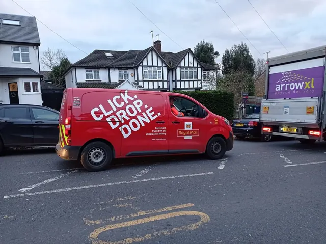 A red Royal Mail van with Click and Drop branding on a UK street.