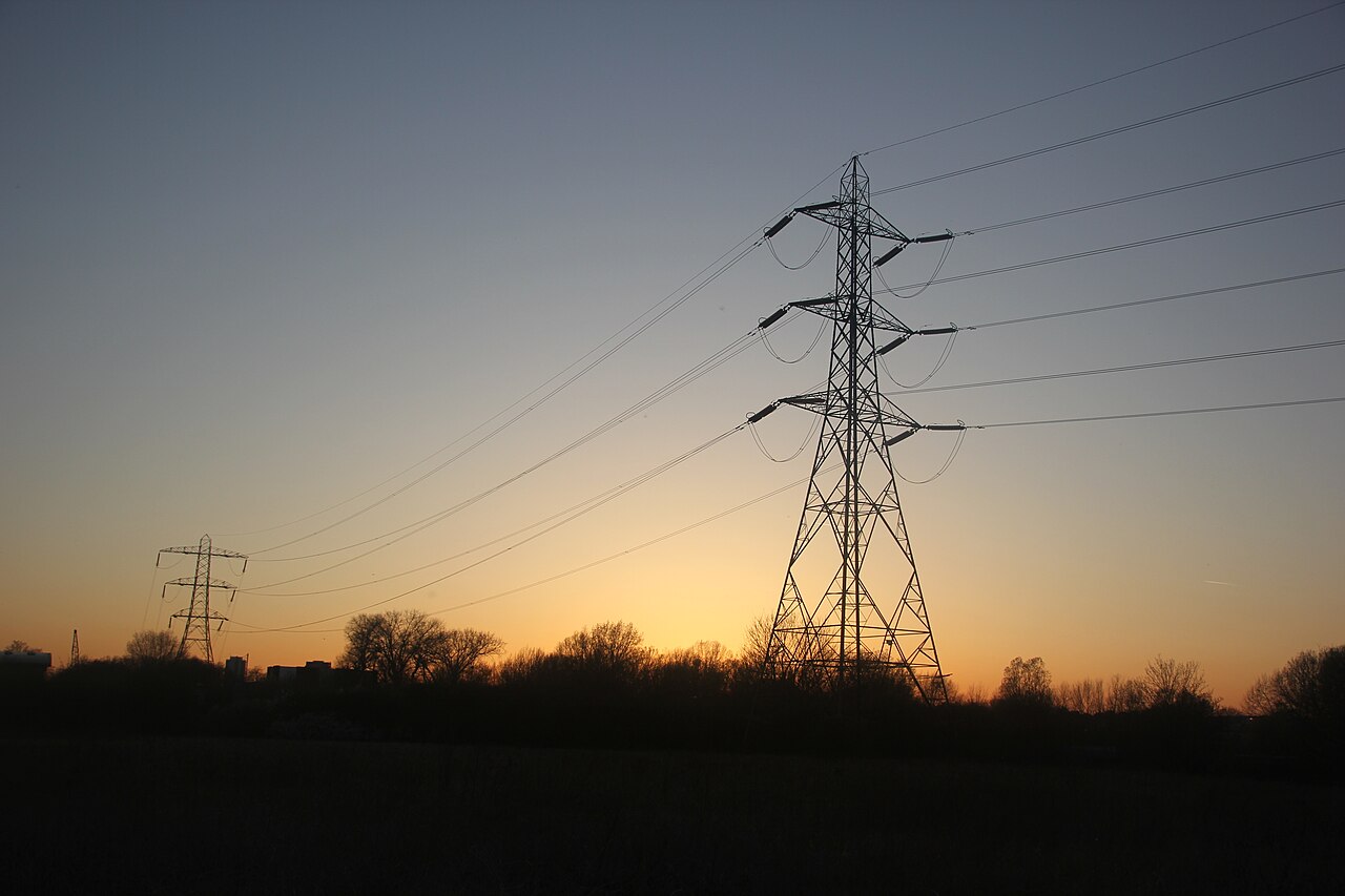Electricity pylons at sunset over Hackney Marshes in London.