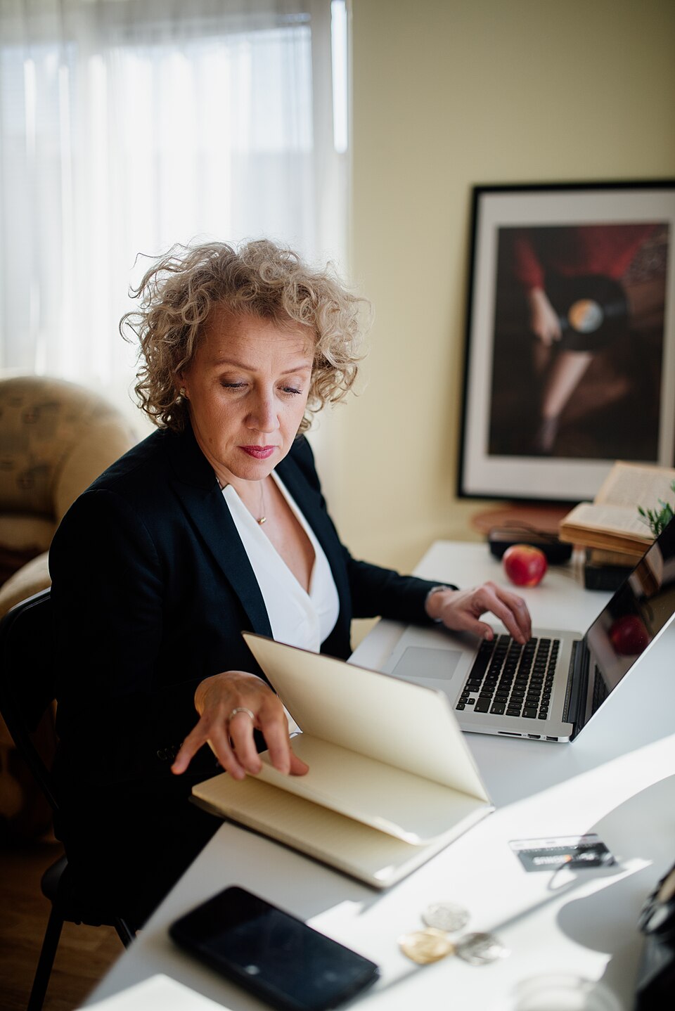 A person reviewing paperwork beside a laptop at an office desk