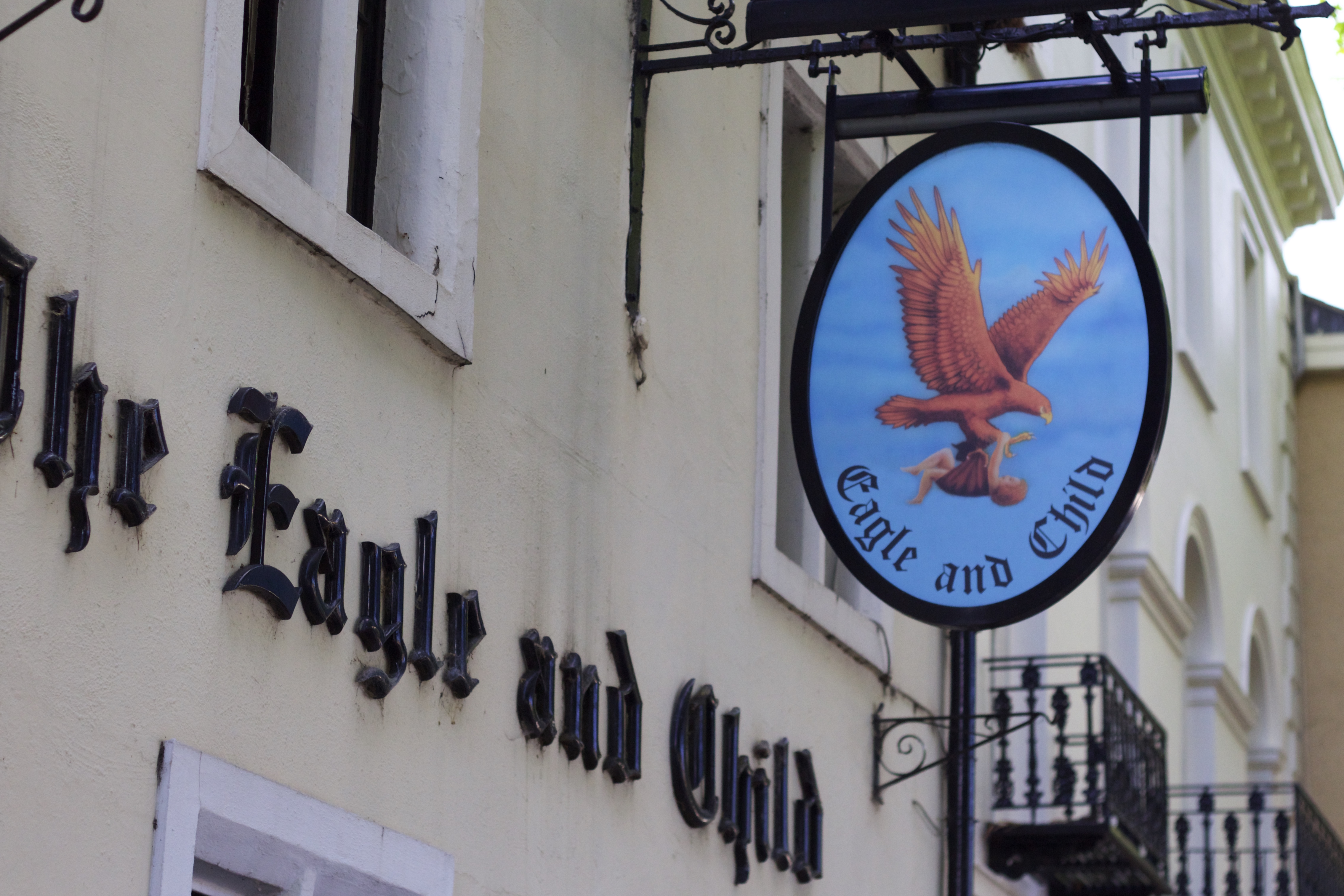 The Eagle and Child pub sign on the exterior wall of the Oxford pub.