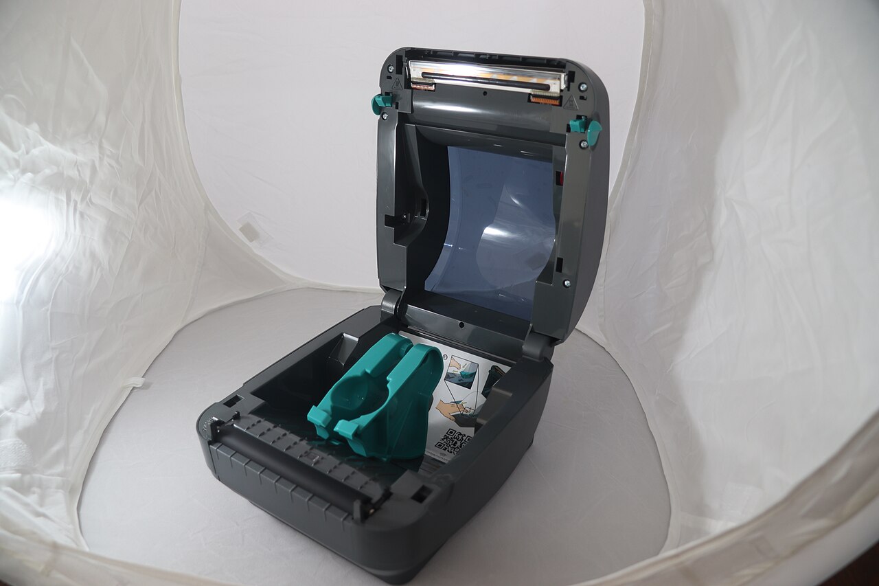 An open Zebra GK420d label printer showing its paper guides and print mechanism.